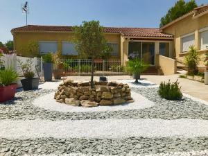 un jardin avec un foyer extérieur en face d'une maison dans l'établissement Chambre d'hôtes Costa Belle, à Lunel-Viel