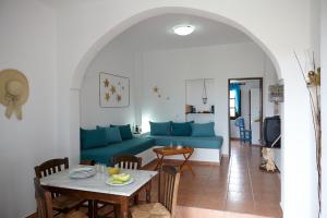 a living room with a blue couch and a table at Anna Traditional Apartments in Kamari