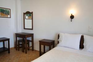 a bedroom with a bed with two tables and a mirror at Kimite in Armenistis