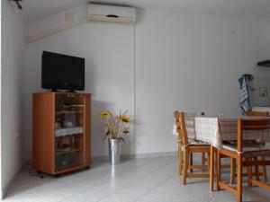 a living room with a television and a table with chairs at Apartment Kurelic in Rab