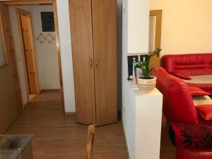 a living room with a red couch and a cabinet at Apartment near the Airport in Sarajevo