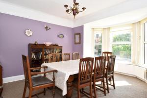 ein Esszimmer mit lila Wänden, einem Tisch und Stühlen in der Unterkunft Boutique Guest House in Galway
