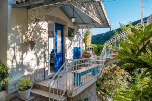a house with a blue door and stairs with plants at Vintage Apartment Nona in Mošćenička Draga