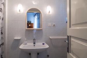 Baño blanco con lavabo y espejo en Vintage Apartment Nona en Mošćenička Draga