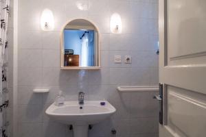 a white bathroom with a sink and a mirror at Vintage Apartment Nona in Mošćenička Draga