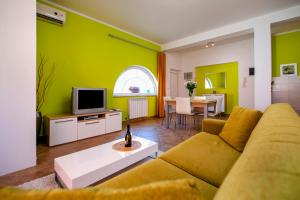 sala de estar con sofá y TV en Apartments Martina, en Rovinj
