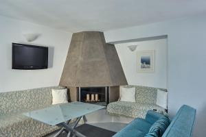 sala de estar con sofá y chimenea en Villa Dakoronia en Fira