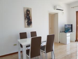 a dining room with a white table and chairs at Apartmani Svetionik in Budva