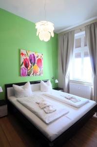ein Schlafzimmer mit einem großen Bett und einer grünen Wand in der Unterkunft Ferienwohnung Warnemünde - L (N) in Warnemünde