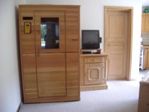 a room with a wooden door and a television at Stoanock Diamant in Bad Kleinkirchheim