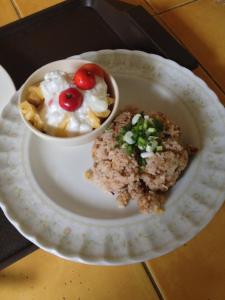 un piatto bianco con una ciotola di cibo su un tavolo di Baan Bua Guest House a Chiang Rai