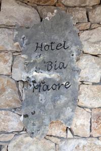 a sign that says hotel bmomo on a stone wall at Hotel Bia Maore in Baunei