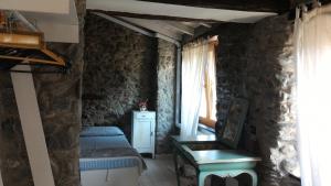 a bedroom with a bed and a chair and a window at Casa La Rosa in Coreglia Ligure