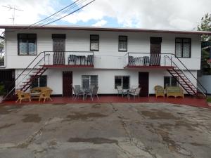 a white house with two balconies and tables and chairs at At Rachel in Paramaribo