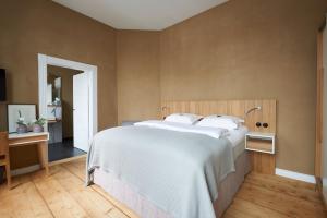 a bedroom with a large bed with white sheets at Alte Apotheke in Bad Essen