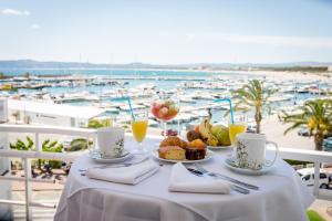 una mesa con comida y bebida y vistas al puerto en Hotel & Diving Les Illes, en L'Estartit