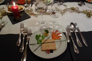 ein weißer Teller mit Essen auf einem Tisch mit Besteck in der Unterkunft Hôtel du Chamois in L'Etivaz