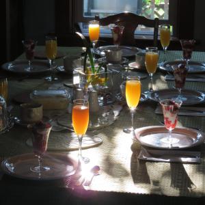 a table with glasses of orange juice on it at Phoenix House B&B in Stettler