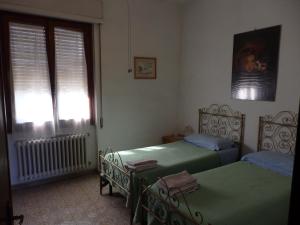 2 camas individuales en un dormitorio con ventana en Residence Casprini da Omero en Greve in Chianti