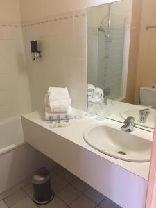 a bathroom with a sink and a mirror at Hôtel Le Dauphin in Saint-Denis-de lʼHôtel