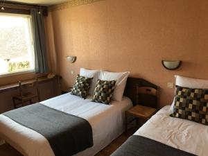 - une chambre avec 2 lits et une fenêtre dans l'établissement Hôtel Le Dauphin, à Saint-Denis-de-l'Hôtel