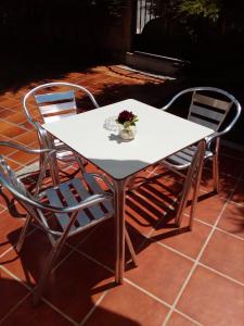 ein weißer Tisch und Stühle mit einer Blumenvase drauf in der Unterkunft Casa Balea in Balea