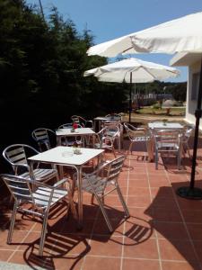a group of tables and chairs with white umbrellas at Casa Balea in Balea