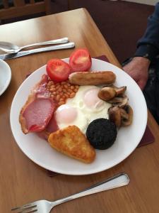 un piatto di prodotti per la colazione su un tavolo di Arkaig Guest House ad Aberdeen