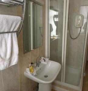 a bathroom with a sink and a shower at Arkaig Guest House in Aberdeen