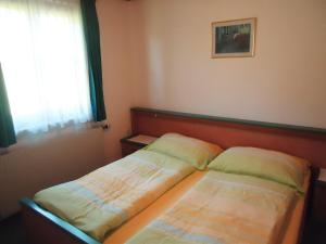 two beds in a small room with a window at Pension Wald in Faistenau