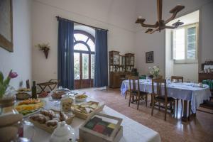 una sala da pranzo con tavolo e cibo di Villa De Pietro a Cursi