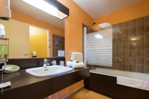 a bathroom with a sink and a mirror at Hôtel Logis Atrium Epinal Golbey Chavelot in Épinal