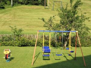 an empty swing set in a yard at Pension Wald in Faistenau