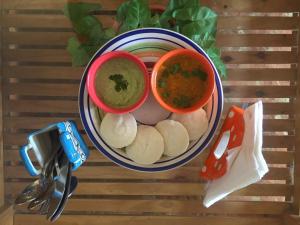 a bowl of food with dipping sauce and dumplings at Villa Baywalk Goa - 200 meters from Morjim Beach in Morjim