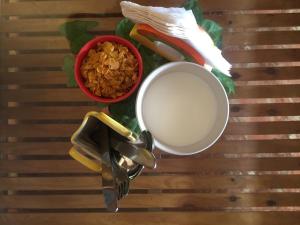 a table with a cup of milk and a bowl of nuts at Villa Baywalk Goa - 200 meters from Morjim Beach in Morjim