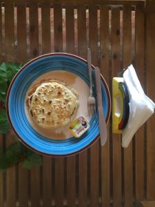 a bowl of soup with a piece of bread and a fork at Villa Baywalk Goa - 200 meters from Morjim Beach in Morjim