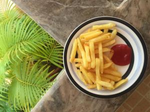 a bowl of french fries and ketchup on a table at Villa Baywalk Goa - 200 meters from Morjim Beach in Morjim