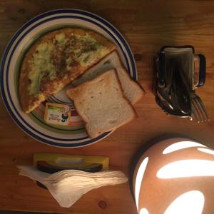 a plate of food with a slice of pizza and toast at Villa Baywalk Goa - 200 meters from Morjim Beach in Morjim