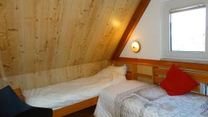 um pequeno quarto com uma cama e uma janela em Vakantiehuis BuitenGewoon em Wissenkerke