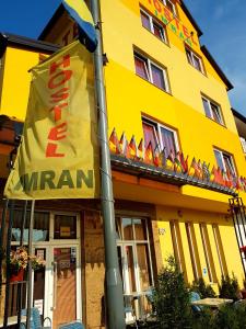 a yellow building with a sign in front of it at Hostel Imran Zenica in Zenica
