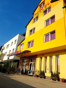 a yellow building on the side of a street at Hostel Imran Zenica in Zenica