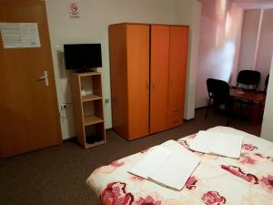 a bedroom with a bed and a cabinet and a television at Hostel Imran Zenica in Zenica