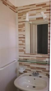un bagno con lavandino e specchio di Ai Tre Scalini a Valderice Altre 37 foto