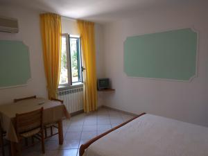 a room with a table and a bed and a window at Residence Giardino del Sole in Ischia