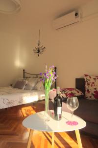 a table with a bottle of wine and a vase of flowers at Studio Apartment Slavi in Pula