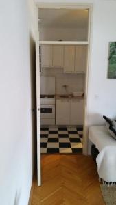 una cocina con una puerta que da a una habitación con suelo a cuadros en Center Apartment, en Budva
