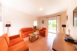 una sala de estar con 2 sofás naranjas y una mesa. en Olive Tree Villa en Herceg-Novi