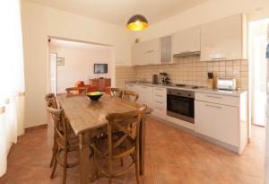 kuchnia z drewnianym stołem i krzesłami w obiekcie Olive Tree Villa w mieście Herceg Novi