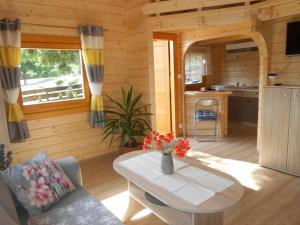- un salon avec une table dans une cabane en rondins dans l'établissement Domek pod Świerkiem, à Wapnica