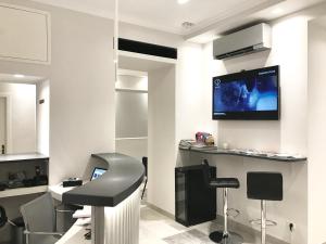 a hair salon with a barber chair and a tv on the wall at Boutique Hôtel Neptune Nice in Nice